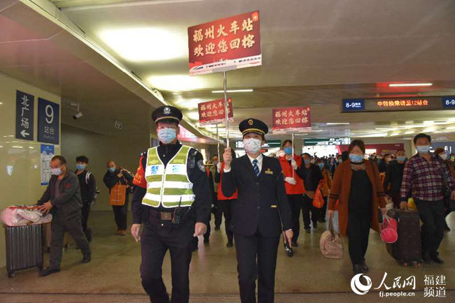 福州火車站黨團(tuán)員青年突擊隊(duì)和值班鐵路民警引導(dǎo)旅客出站。 江曲攝