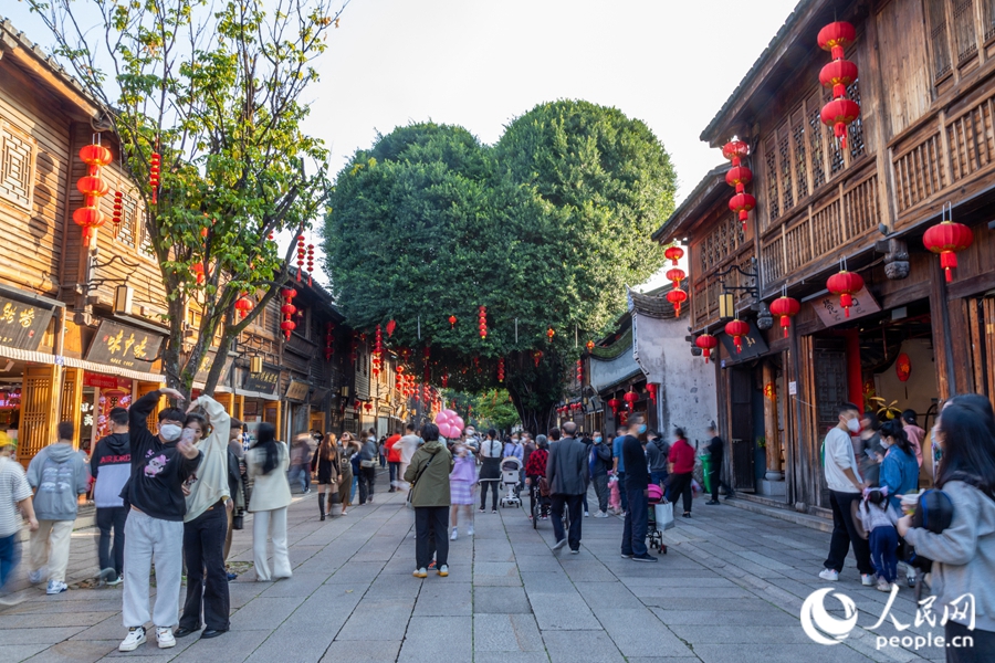 市民在三坊七巷的“愛心樹”下合影留念?？道跀z