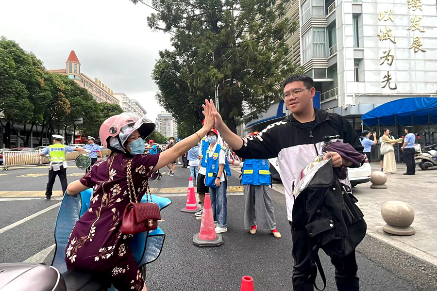 8.高考首日，送考家長(zhǎng)與考生擊掌祝福。毛朝青 攝