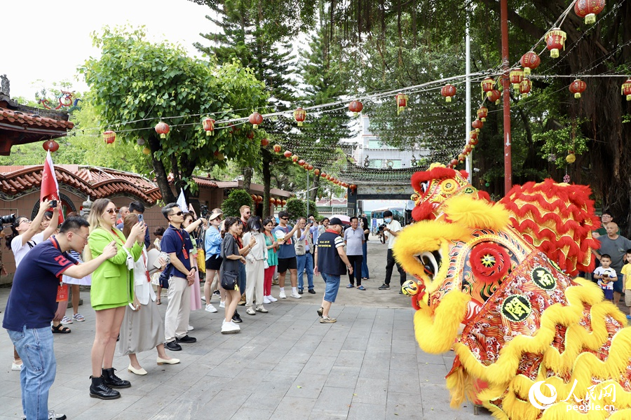 看到海澄城隍廟舞獅精彩表演，中外媒體采訪團(tuán)的成員們紛紛拿出手機(jī)拍照記錄。人民網(wǎng) 謝小姿攝