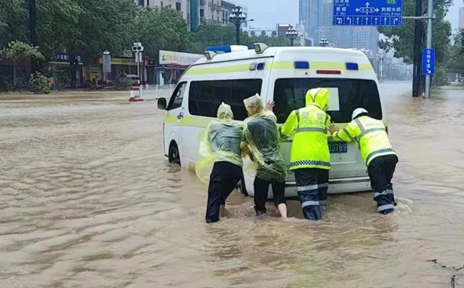 晉江交警合力將拋錨的救護車推離積水路段。泉州公安供圖