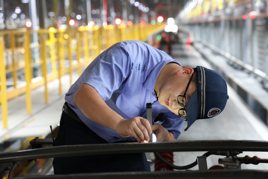 動車組機(jī)械師在檢修智能復(fù)興號動車組車頂高壓設(shè)備。福州動車段供圖