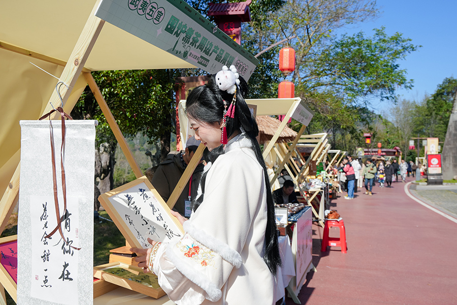 身穿漢服的游客駐足欣賞工藝品。武夷山市數(shù)字武夷電子商務(wù)發(fā)展有限公司供圖