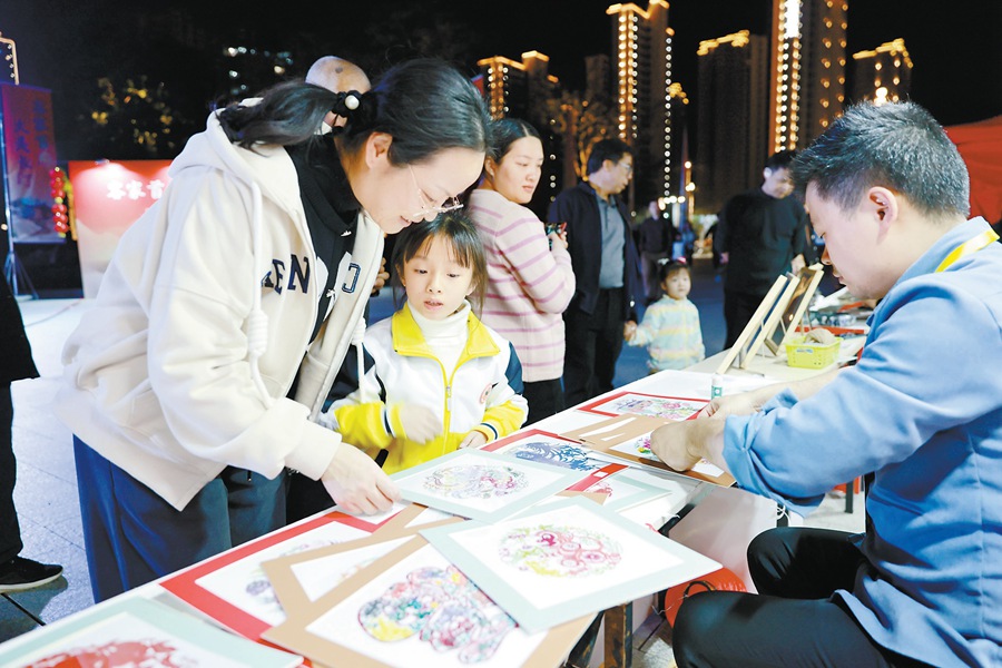 年貨大集市民觀賞非遺技藝剪紙。