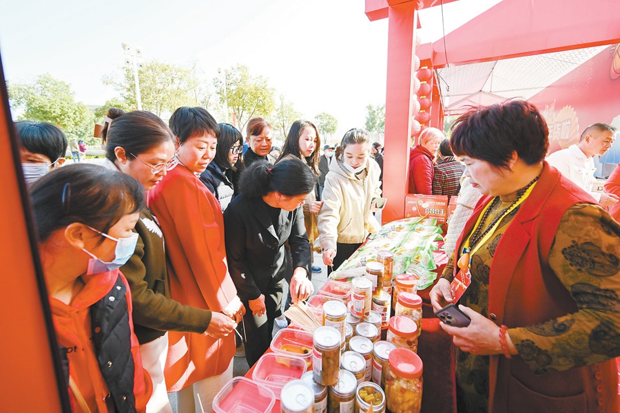 市民在年貨大集品嘗、購(gòu)買非遺年貨。