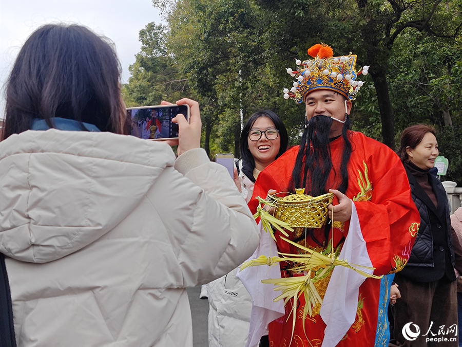 游客在西街路遇“財神爺”。人民網(wǎng) 黃東儀攝