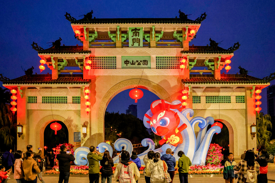 中山公園牌坊上懸掛著大紅燈籠，“福瑞龍”踏浪造型布景引人注目。楊勁堅攝