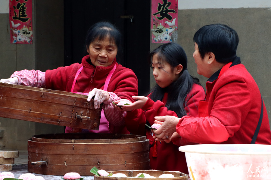 將壓印成型的紅團(tuán)送進(jìn)蒸籠。人民網(wǎng)記者 林盈攝