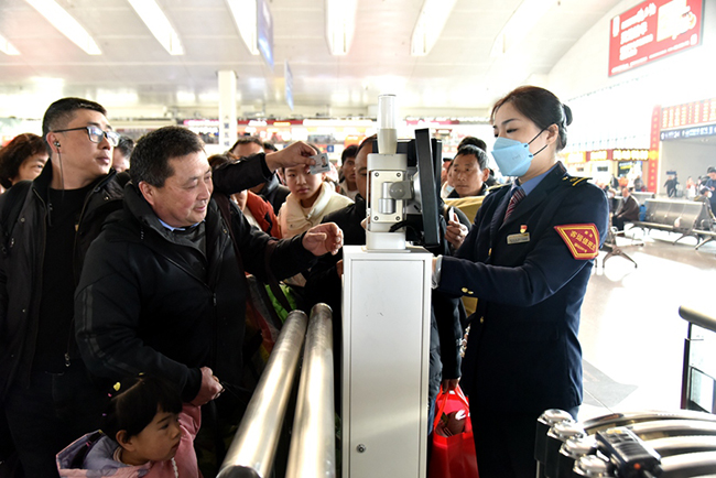 福州火車站工作人員正在幫助旅客快速檢票進站乘車。江曲攝