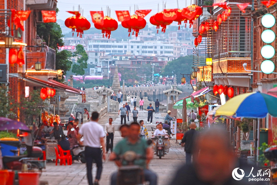 夜幕降臨，洛陽(yáng)橋在橋南古街燈光的點(diǎn)綴下，宛如披上了一層金色的輕紗，熠熠生輝。人民網(wǎng) 李昌乾攝