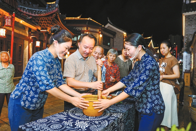 市民在武平縣興賢坊傳統(tǒng)文化街區(qū)體驗(yàn)客家擂茶